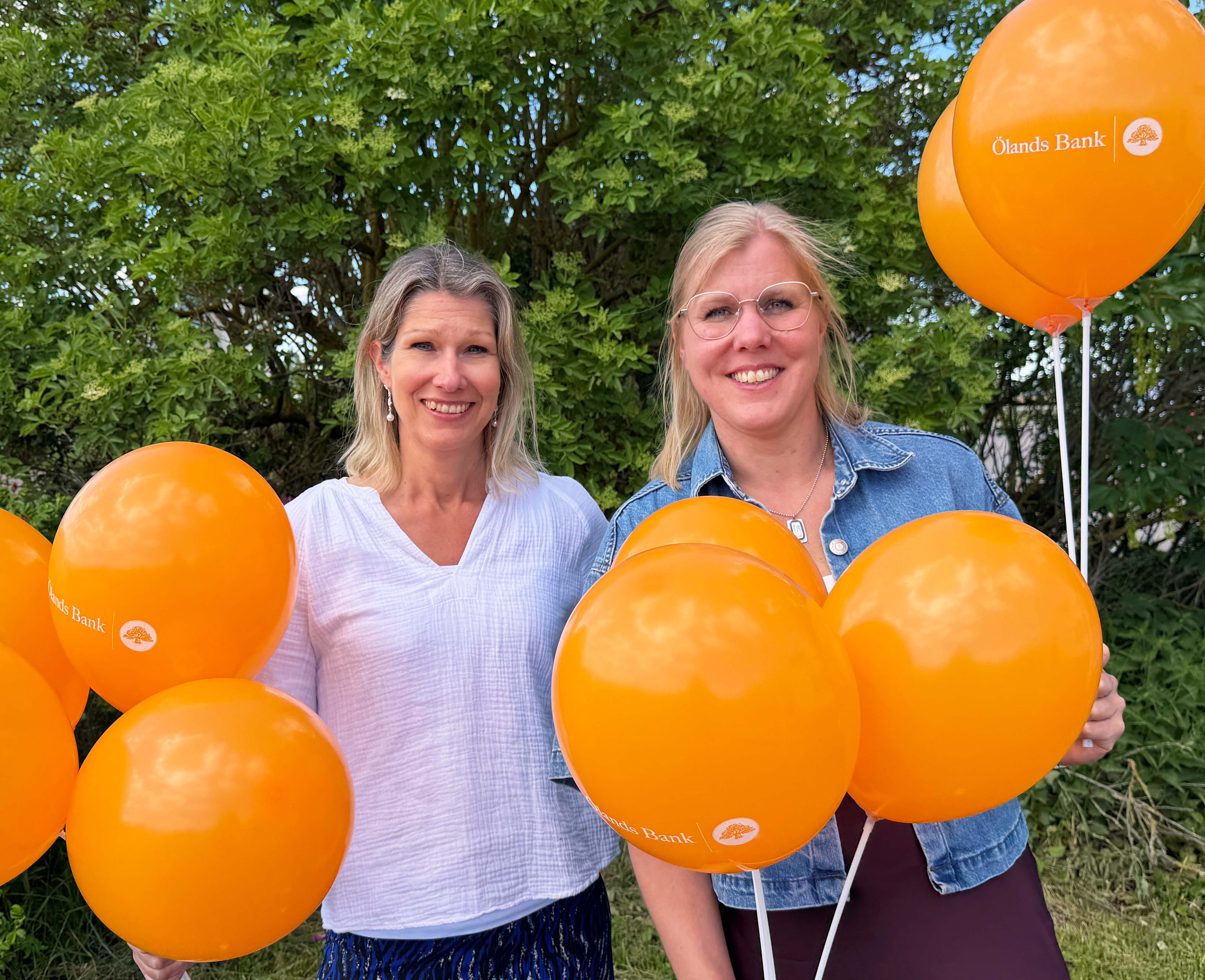 Two people holing orange balloons in their hands. 