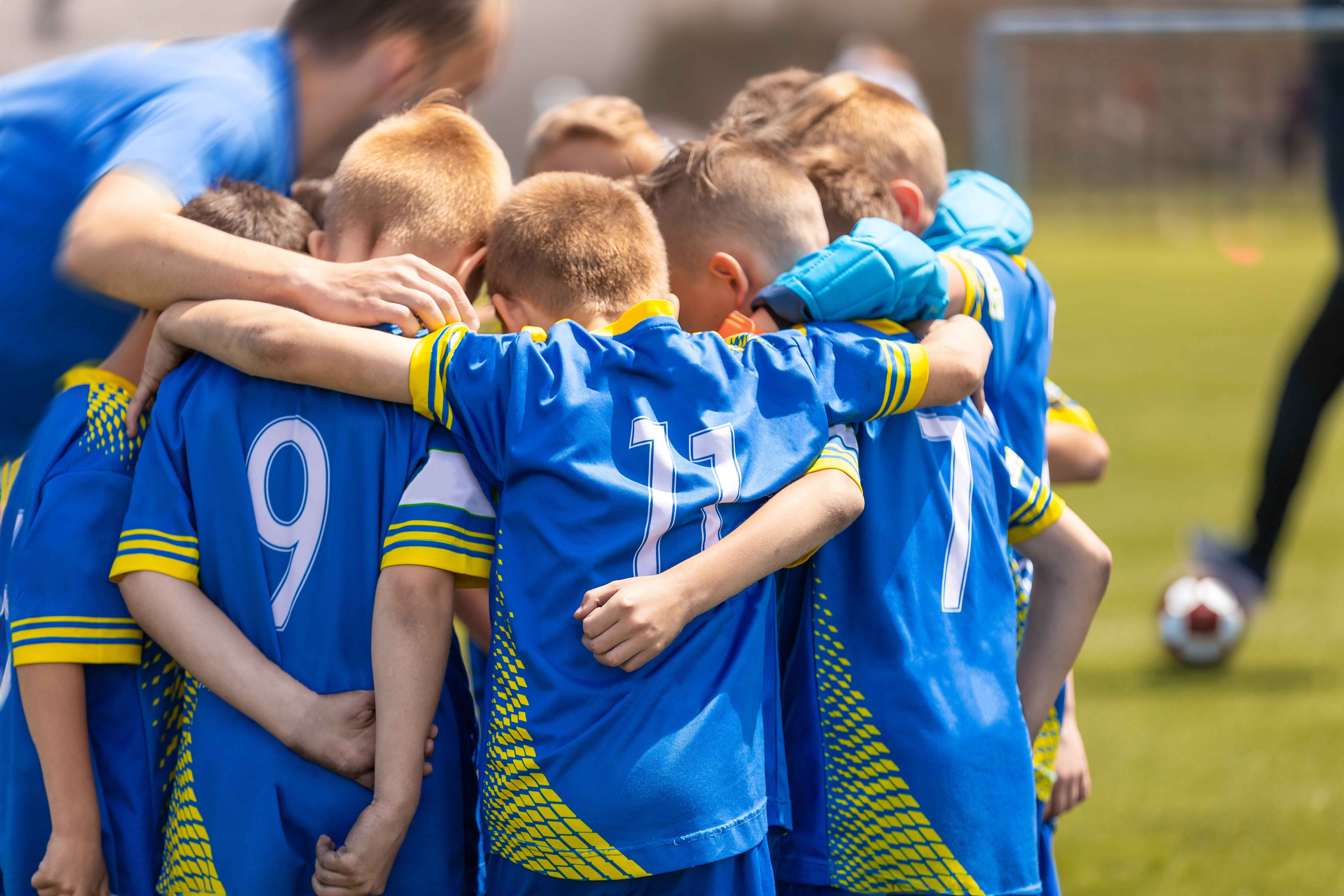 Football kids gives each other a big hug.