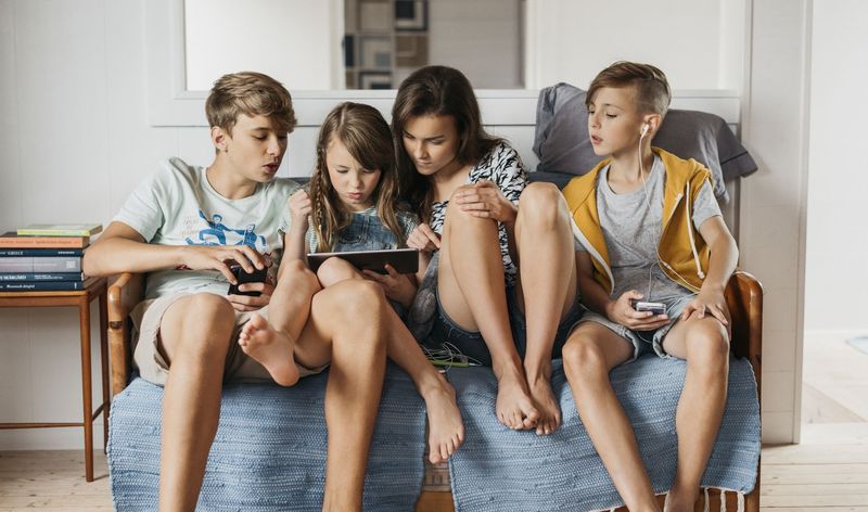 Kids watching iPad in sofa